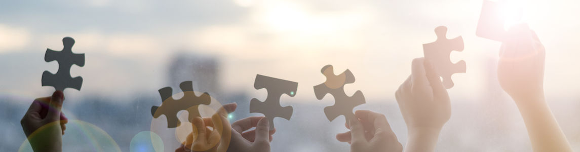 Delle mani di bambini con dei pezzi di puzzle