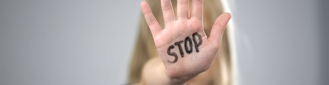 ragazza mostra il palmo della mano con scritto stop