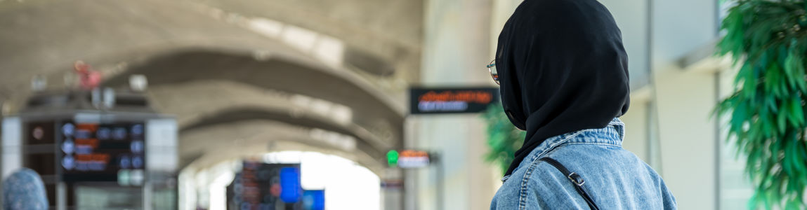 giovane donna con hijab di spalle in aeroporto