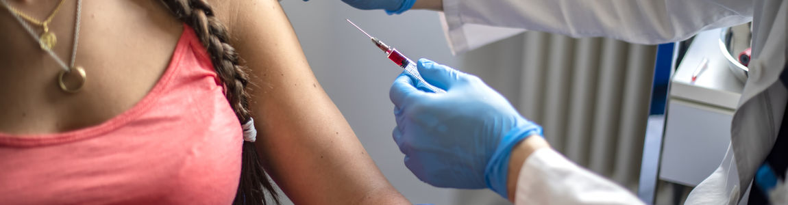 medico disinfetta la pelle di una paziente prima di fare una vaccinazione