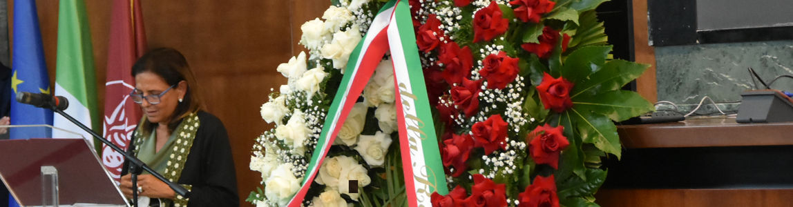 La Rettrice nel discorso di saluto con dietro la corona di fiori