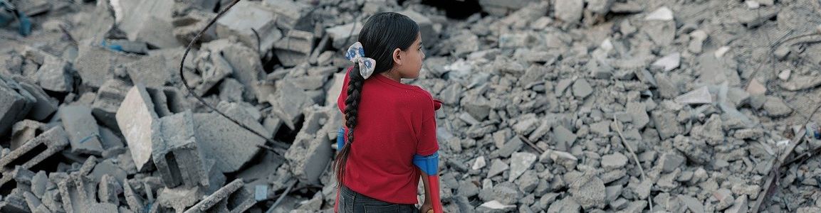bambina senza una gamba davanti alle macerie
