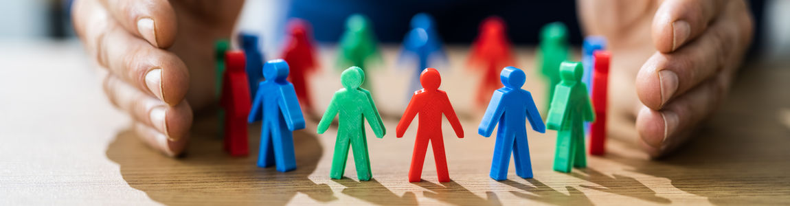 mani che proteggono pedine diverse tra di loro