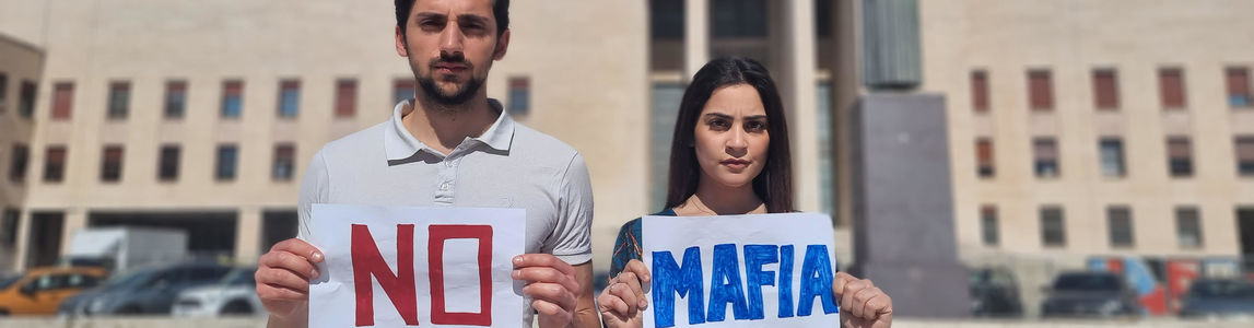 Foto di uno studente e una studentessa con due cartelli in mano con scritto No Mafia