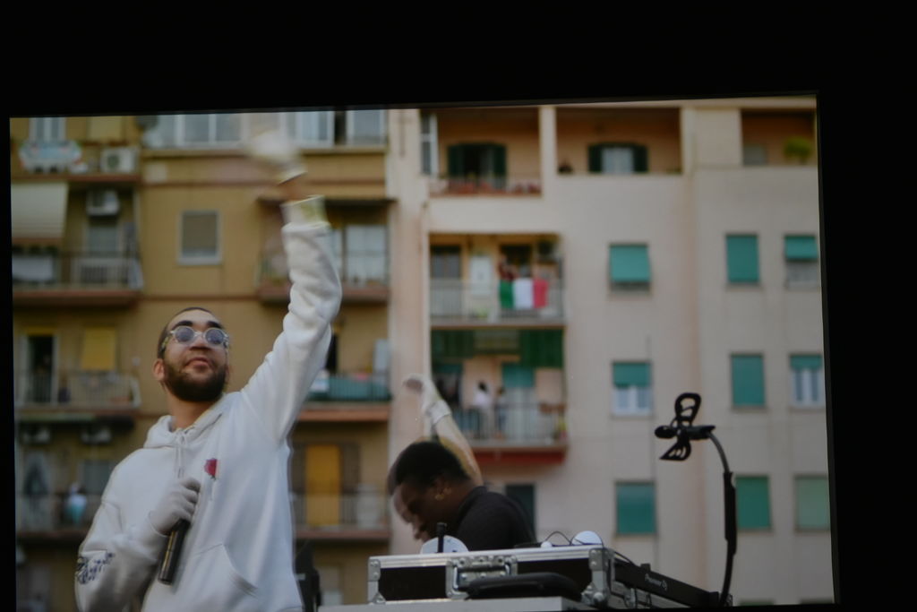 Un fotogramma del documentario; un ragazzo che suona in un cortile di un palazzo