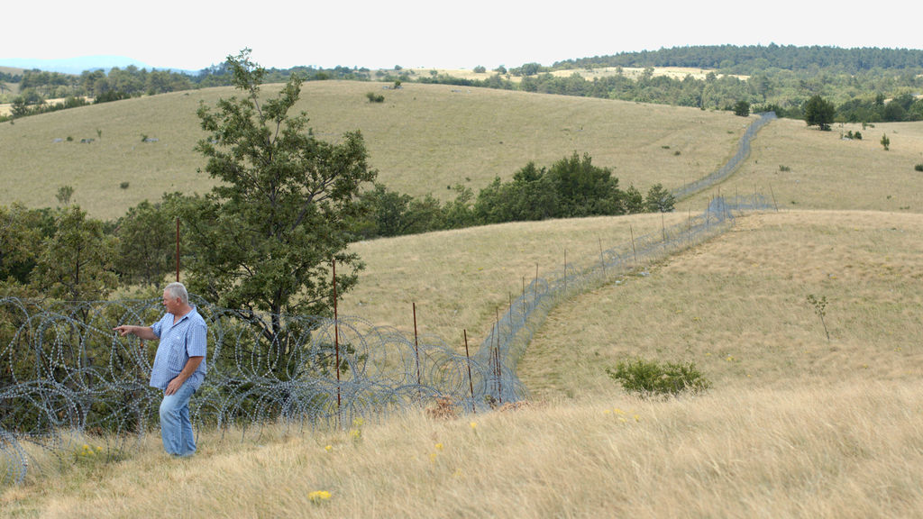 Campo di grano con anziano e filo spinato