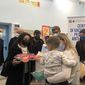 Studentessa di Sapienza in Movimento che porge un regalo a una bambina